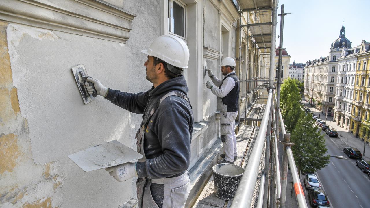 Fachkräfte erneuern den Putz einer Wiener Hausfassade